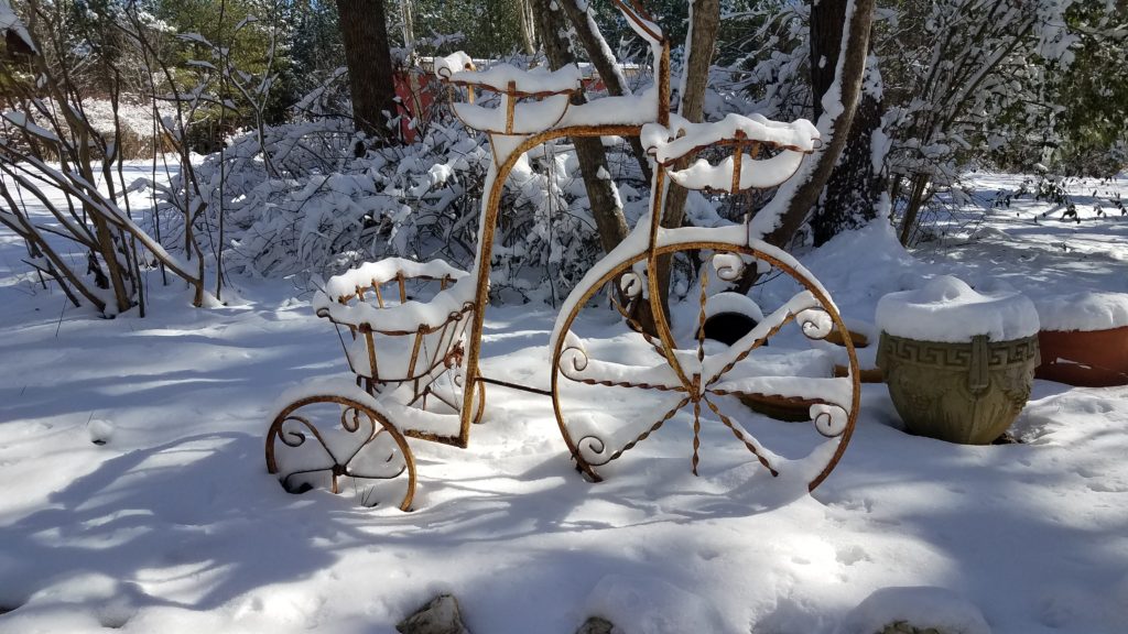 A bicycle with a basket in the middle of snow.