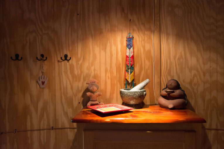 A wooden table with some monkey statues and candles