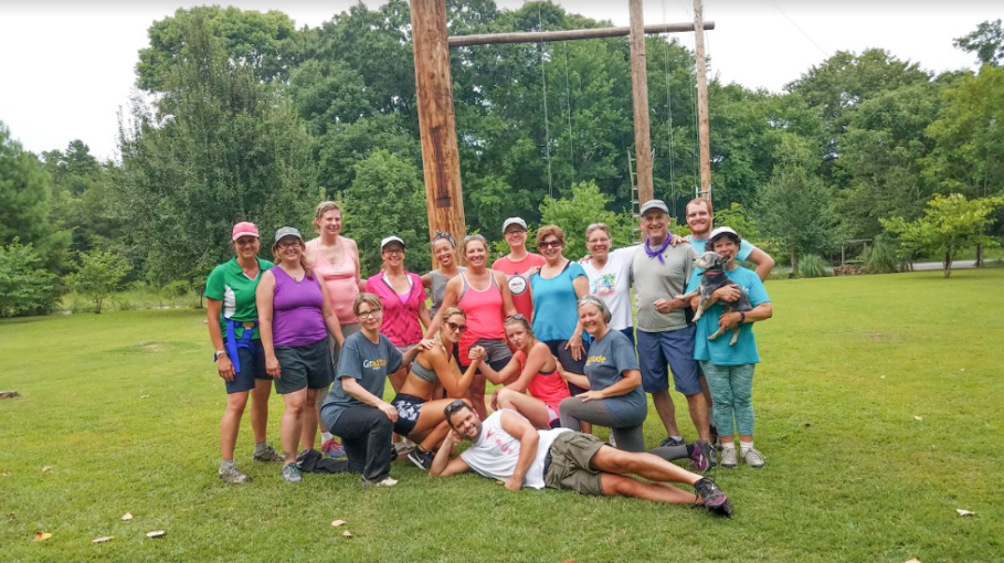 A group of people posing for a picture in the grass.