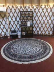 A yurt with a rug in the middle of it.